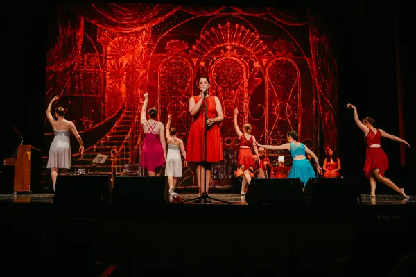 Buehnenshow Saengerin im roten Kleid, dramatische Lichtstimmung