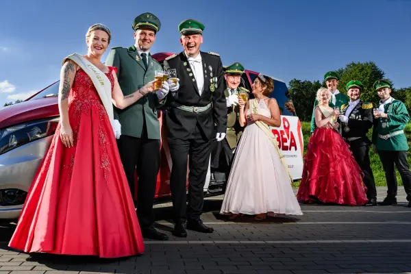 Schuetzengesellschaft in Uniform vor BEA-Van